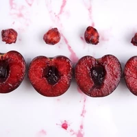 1604607-343760-image-of-fresh-cherries-cut-in-halves-with-seeds-and-cherry-juice-on-white