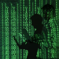 An illustration picture shows projection of binary code on man holding aptop computer in Warsaw