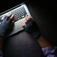 hacker hand stealing data from laptop top down