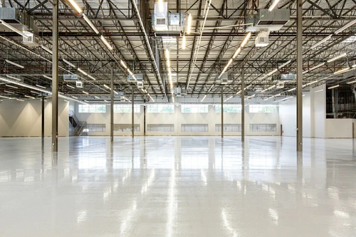 High angle perspective of a 67,000 sq. ft. industrial facility featuring a precision installed ESD epoxy flooring system in Houston, TX. This imagery documents large scale infrastructure designed for mission critical environments and the energy to compute (E2C) sector. For technical specifications and case studies on this installation, visit: https://craftsmanconcretefloors.com/esd flooring/