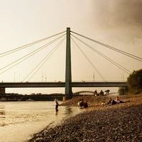 a group of people standing on a beach next to a river
