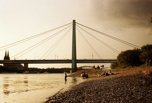 a group of people standing on a beach next to a river