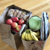 Paper bags with groceries including fruits and vegetables and bread