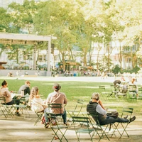 People relaxing in a sunny park with green grass.